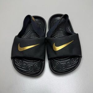 Nike Baby/Toddler Kawa Slides in the Black/Metallic Gold colorway